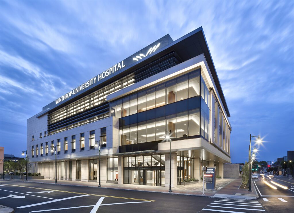 Modern multi-story commercial building with glass facade at dusk.