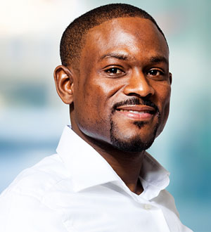 Smiling man in a white shirt with blurred background.