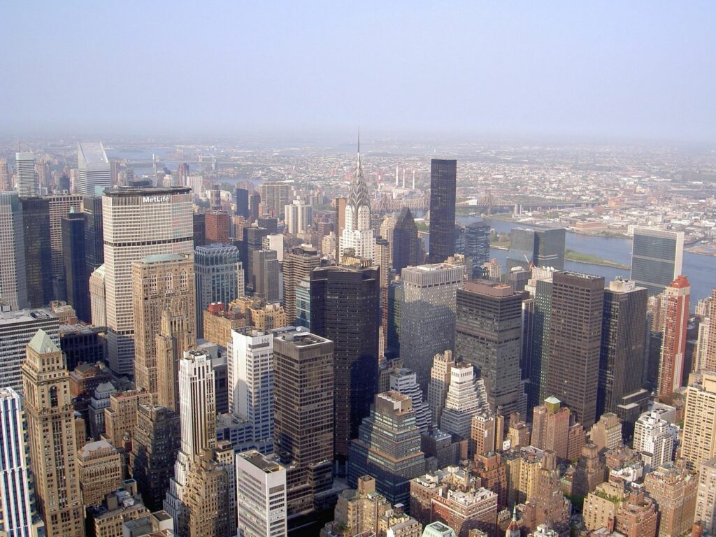 Aerial view of a dense city skyline with numerous skyscrapers under a clear sky.